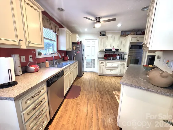 a large kitchen with stainless steel appliances lots of counter space and a sink