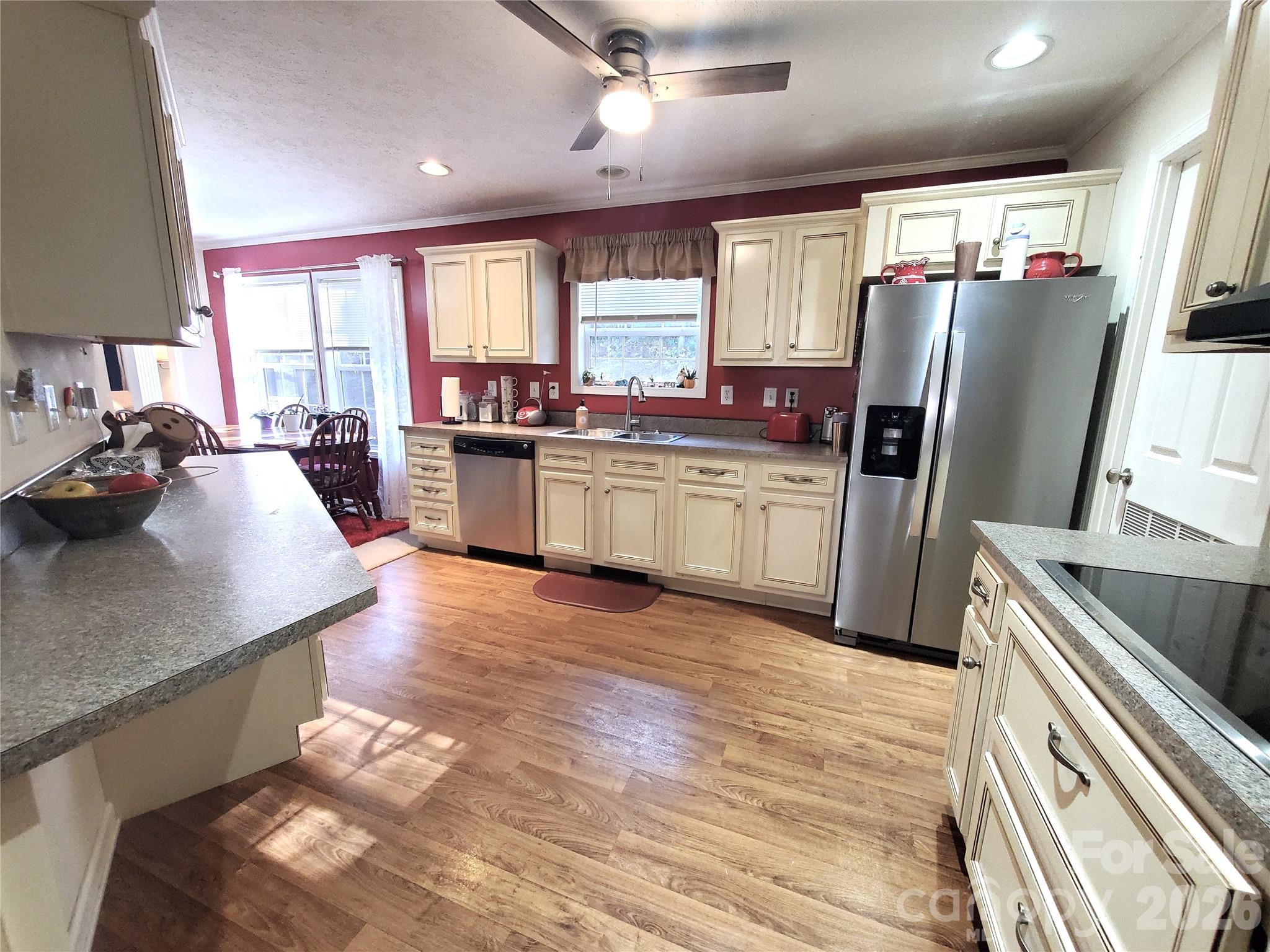 457 Dale Road Spruce Pine, NC 28777 - Photo 6 of 36 a kitchen with stainless steel appliances granite countertop a refrigerator a sink dishwasher a stove and a dining table with wooden floor