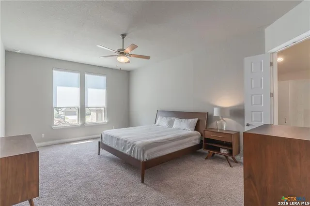 a spacious bedroom with a bed and a chandelier