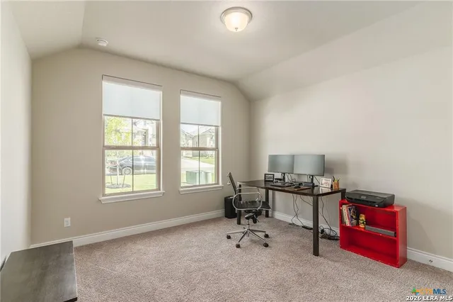 a view of a workspace with furniture and a window