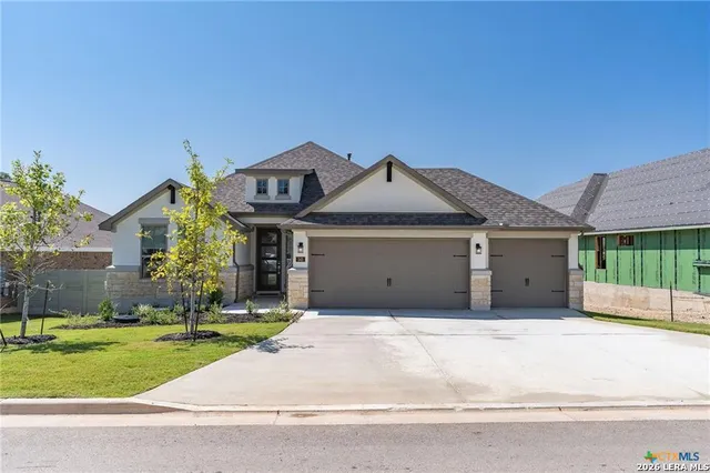 a front view of a house with a garden and plants