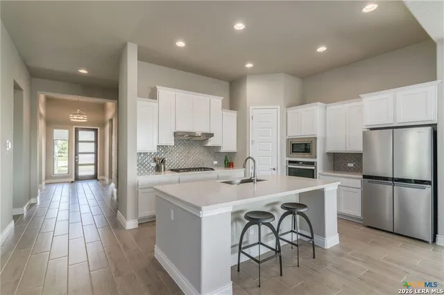 a kitchen with white cabinets and stainless steel appliances