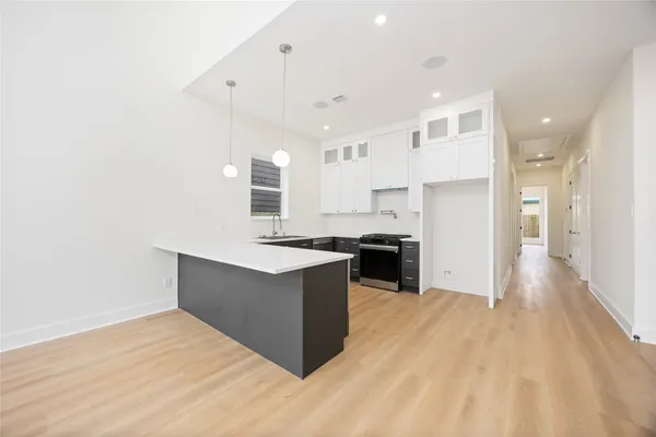 a large kitchen with kitchen island a sink stainless steel appliances and cabinets