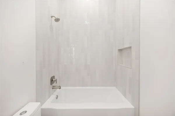 a white bath tub sitting next to a white toilet