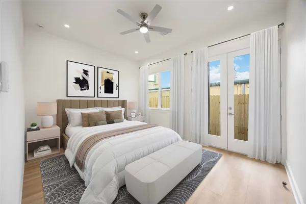 a bedroom with a large bed and a ceiling fan