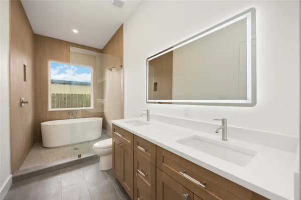 a bathroom with a sink a large mirror and a bathtub