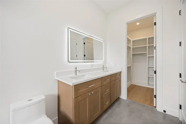 a spacious bathroom with a toilet sink and mirror