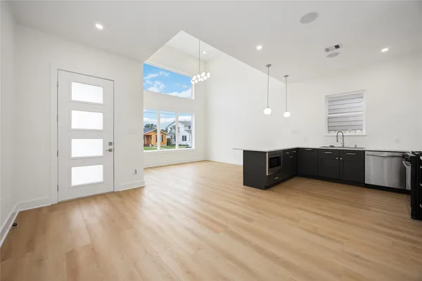 a view of an empty room with window and wooden floor
