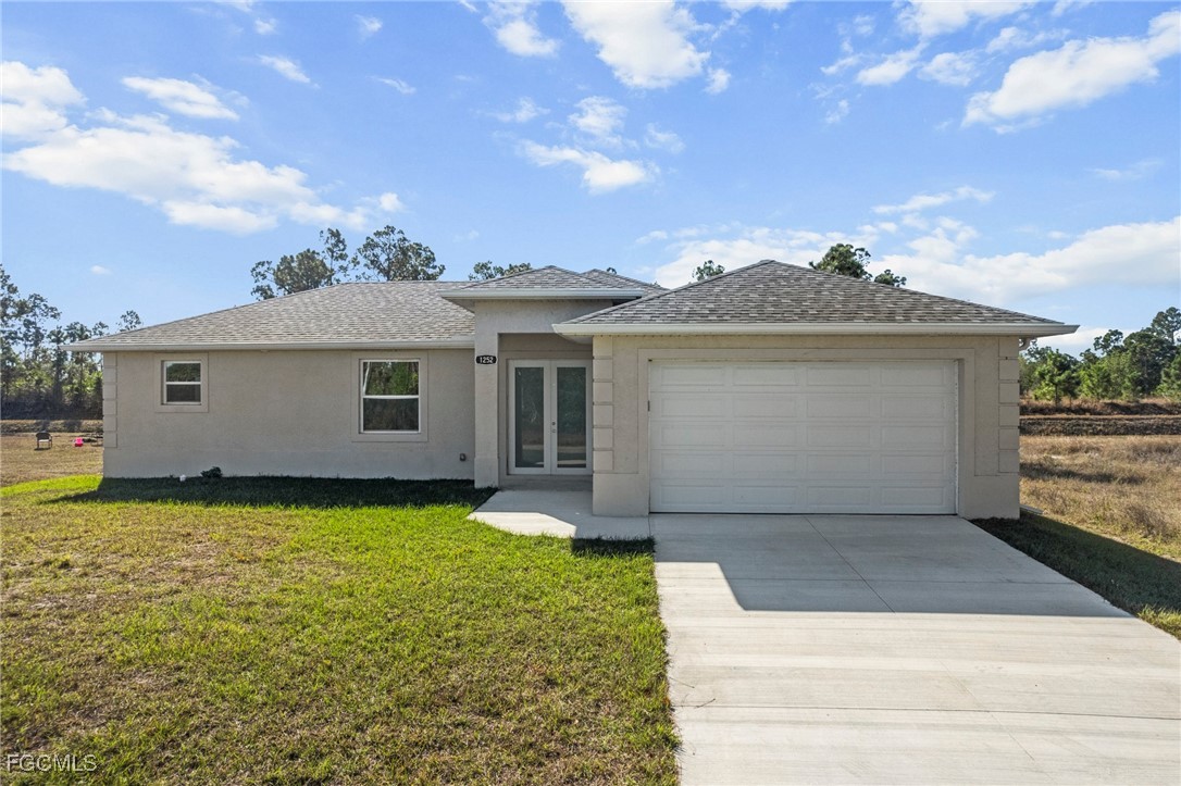 1252 Edna Street East Lehigh Acres, FL 33974 - Photo 20 of 25 a view of a house with garden
