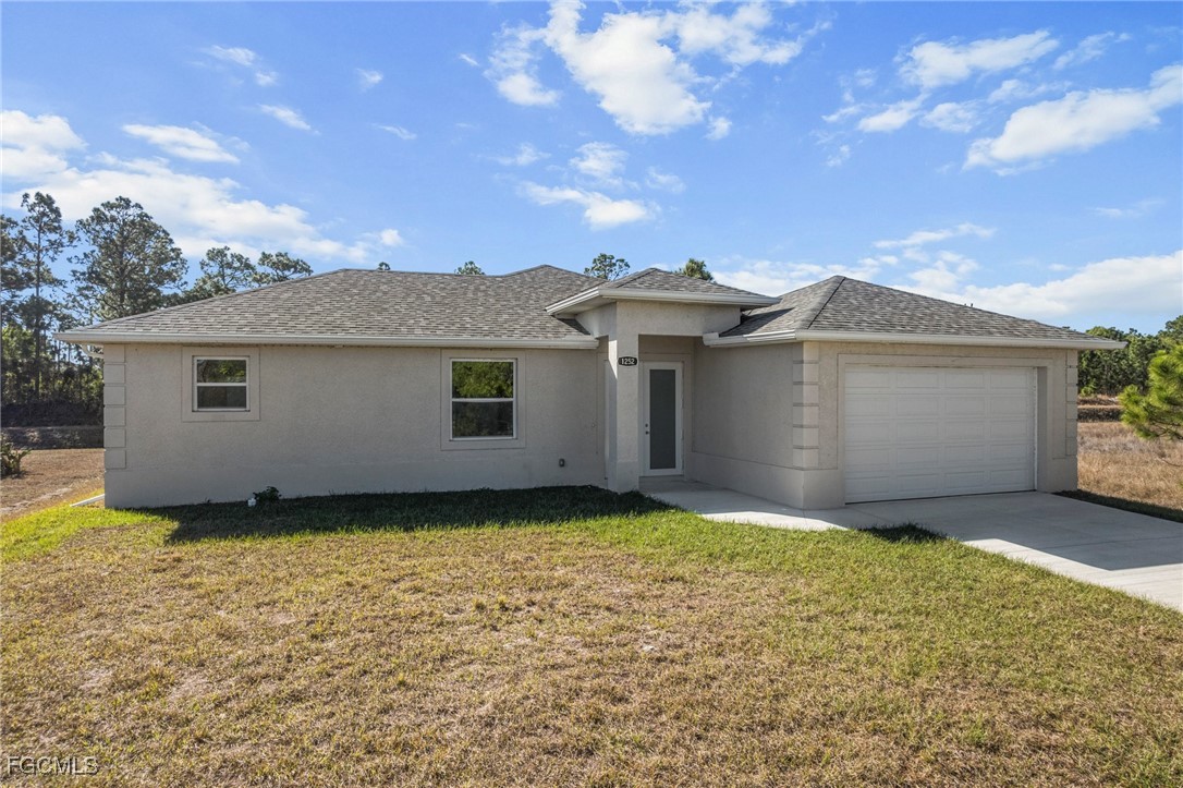 1252 Edna Street East Lehigh Acres, FL 33974 - Photo 22 of 25 a view of a house with a yard