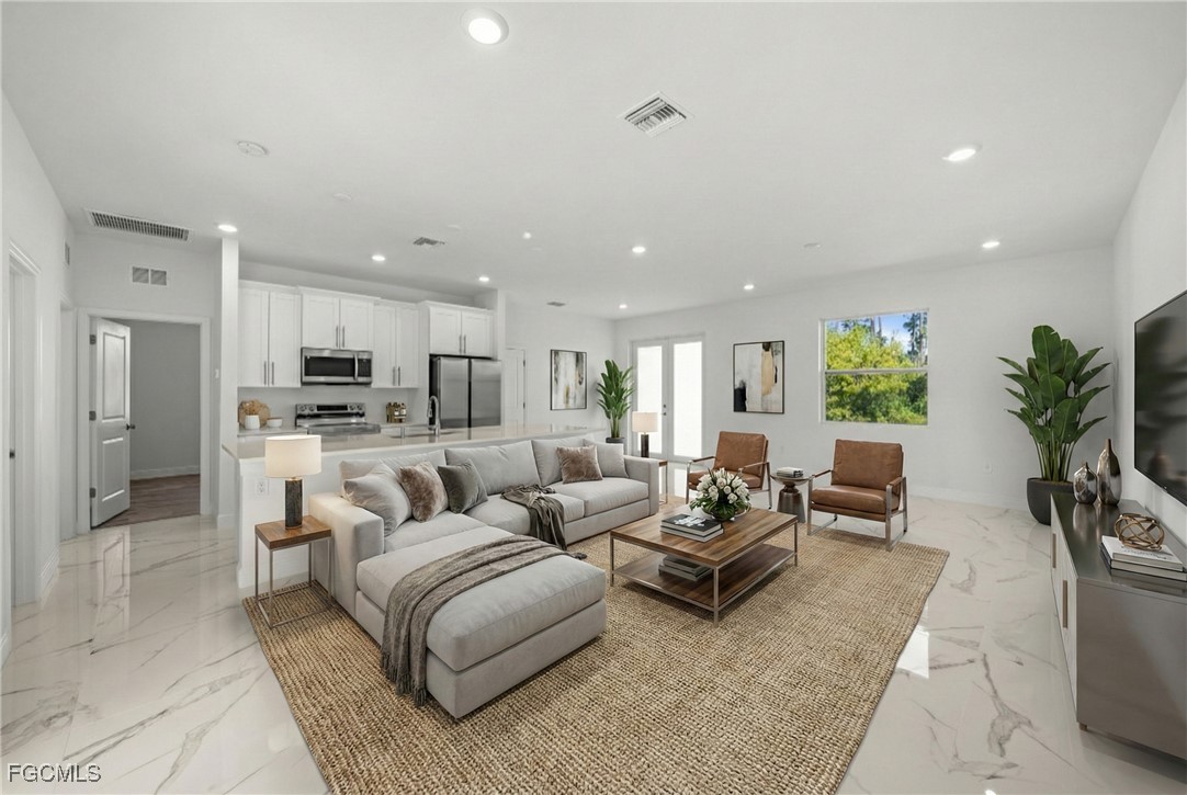 1252 Edna Street East Lehigh Acres, FL 33974 - Photo 3 of 25 a living room with furniture and a large window