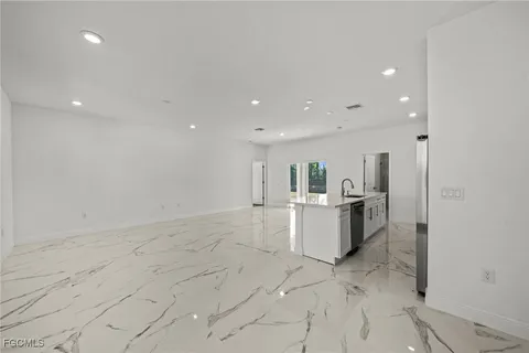 a view of kitchen with refrigerator sink and stove