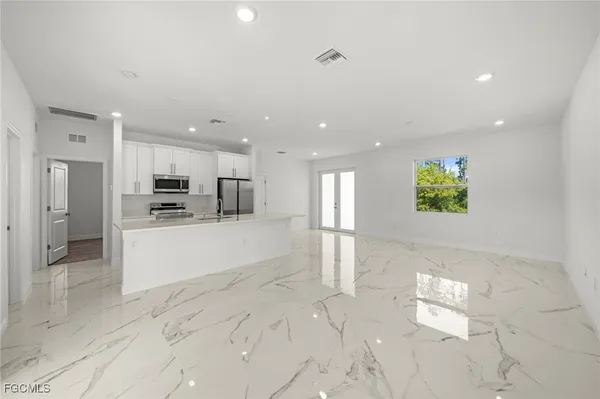 a view of kitchen with kitchen island white cabinets and refrigerator