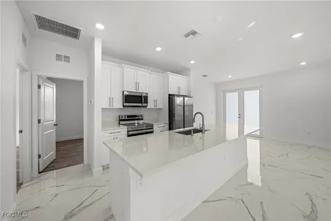 a kitchen with stainless steel appliances a refrigerator and a stove top oven