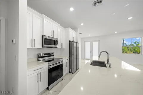a kitchen with stainless steel appliances a sink stove and refrigerator