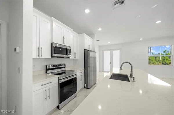 a kitchen with stainless steel appliances a sink stove and refrigerator