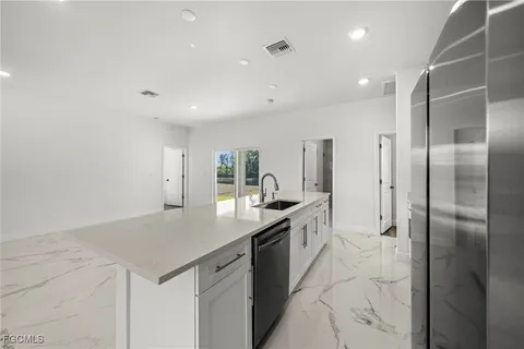 a kitchen with stainless steel appliances granite countertop a sink and a refrigerator
