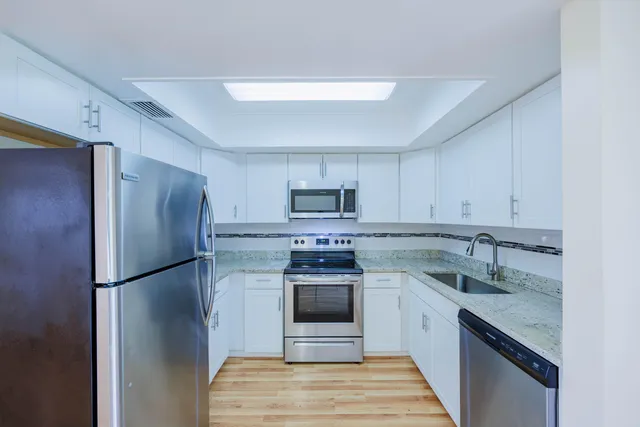 a kitchen with stainless steel appliances granite countertop a refrigerator stove and sink