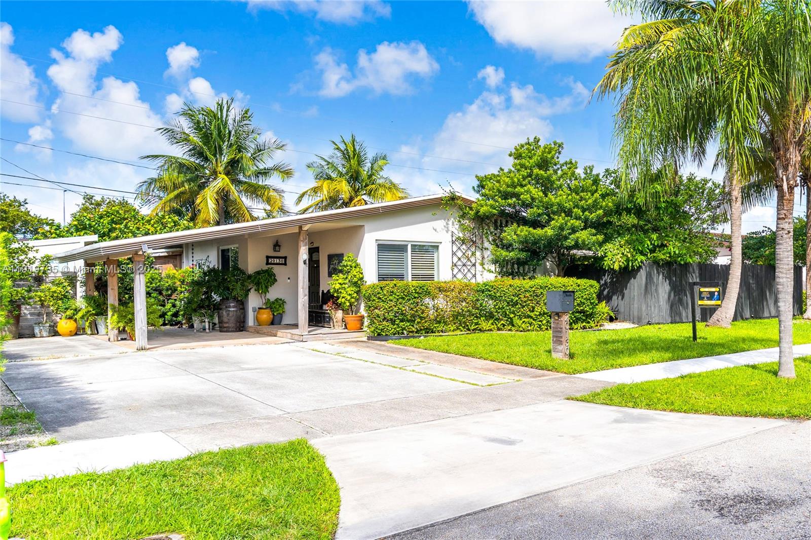 a view of a house with a yard and palm trees