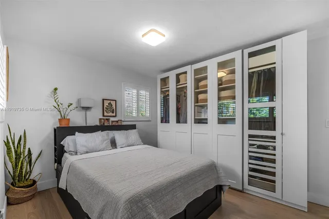 a bedroom with a large bed and a potted plant