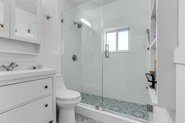 a bathroom with a sink a toilet and shower