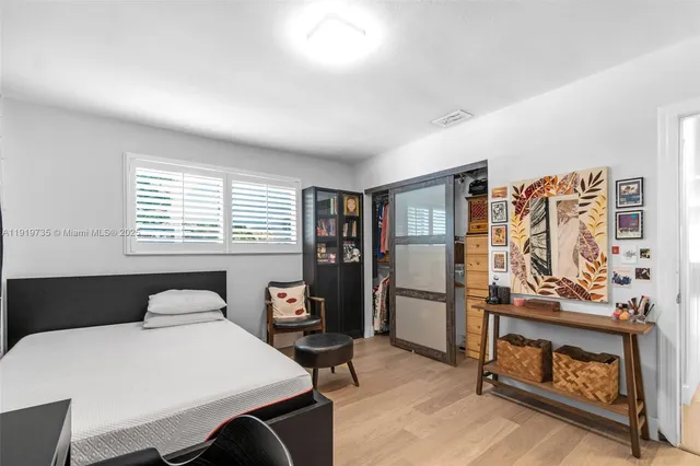 a bedroom with a bed and wooden floor