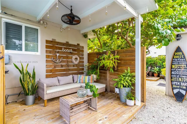 a view of a porch with chairs and potted plants