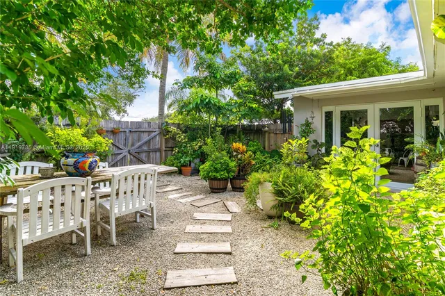 a view of a chair and table in back yard of the house