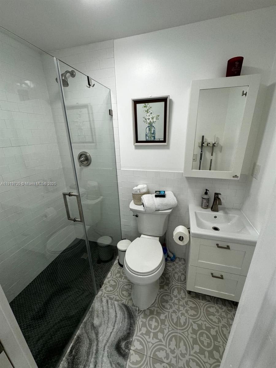 20130 Southwest 106th Court Cutler Bay, FL 33189 - Photo 36 of 42 a bathroom with a toilet sink and shower