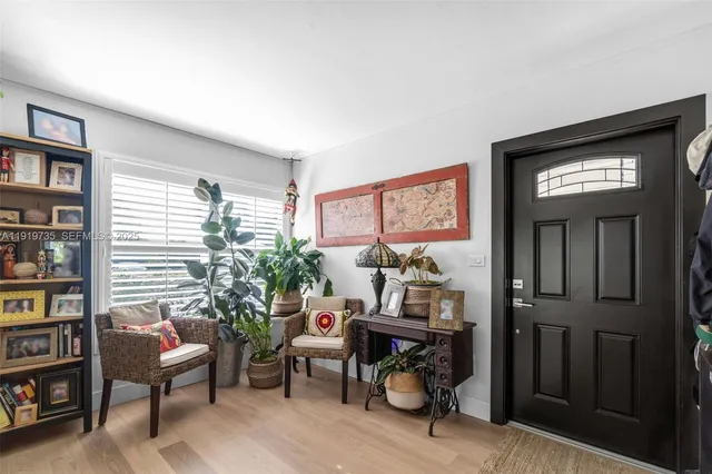 a living room with furniture a bookshelf and a window