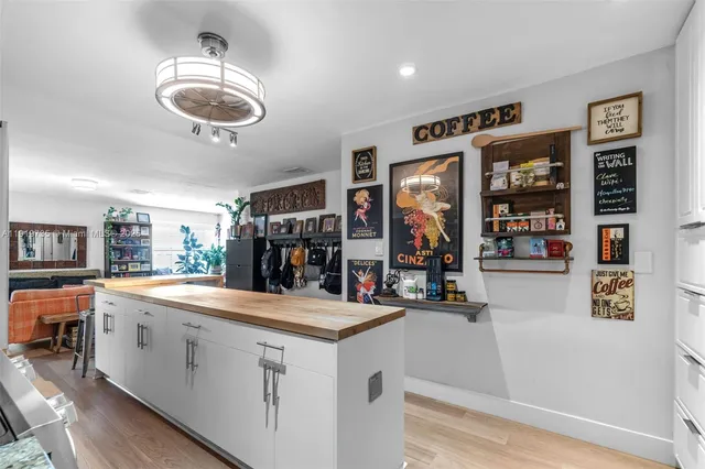 a room with stainless steel appliances kitchen island a large counter space cabinets and furniture