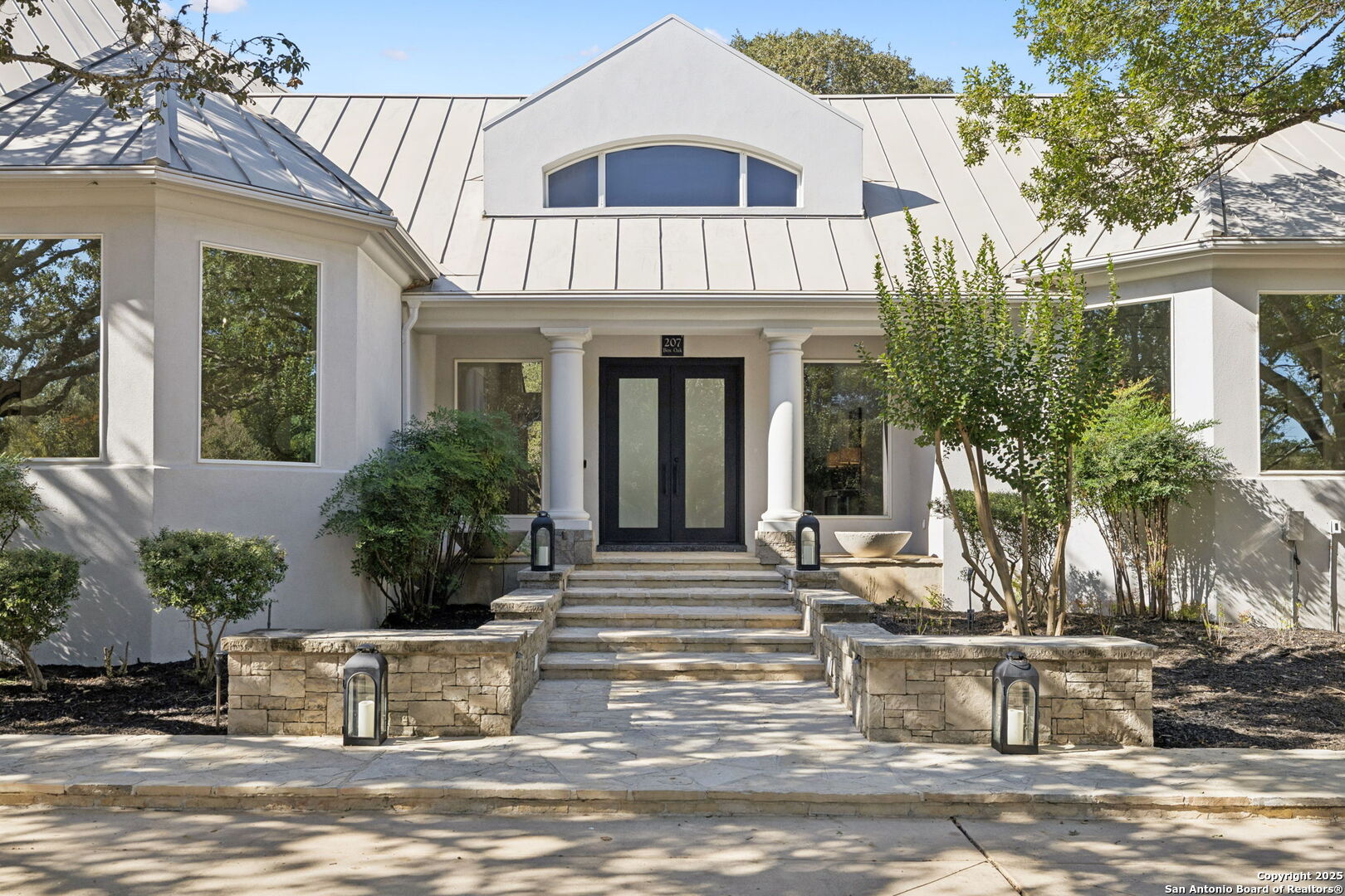 207 Box Oak Shavano Park, TX 78230 - Photo 3 of 50 a view of a white house with large windows and plants
