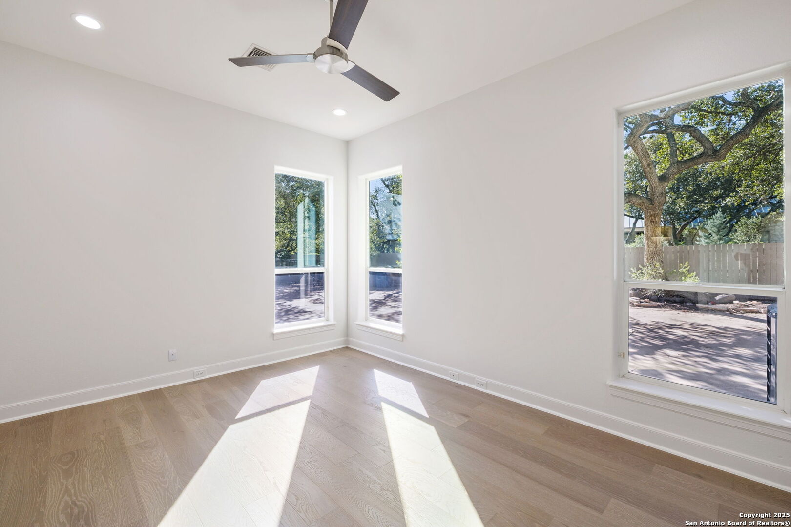 207 Box Oak Shavano Park, TX 78230 - Photo 36 of 50 an empty room with wooden floor fan and windows