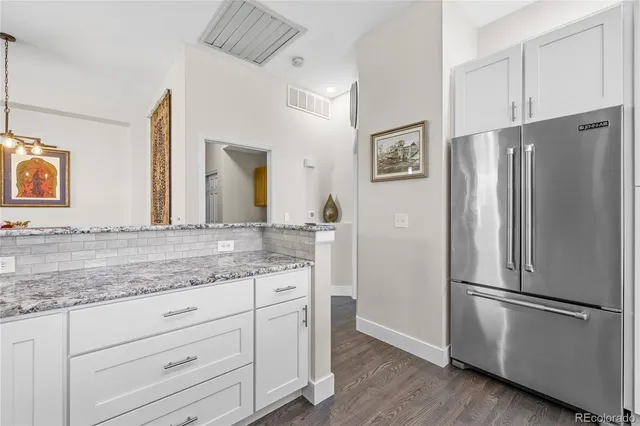 a kitchen with stainless steel appliances granite countertop a refrigerator and a sink