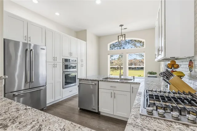 a kitchen with stainless steel appliances granite countertop a sink stove and refrigerator