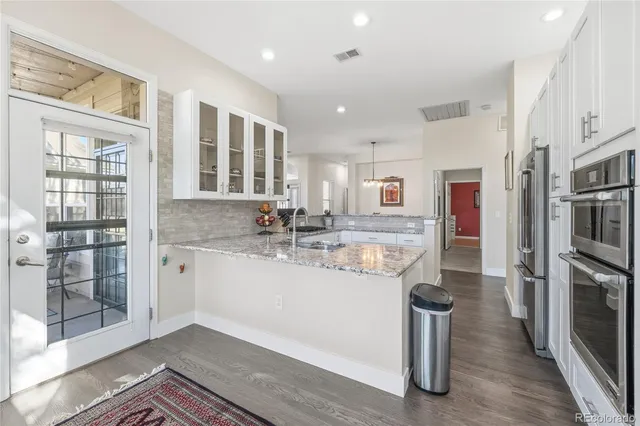 a kitchen with stainless steel appliances granite countertop a refrigerator and a sink