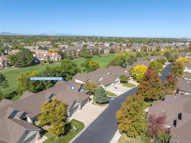an aerial view of a city with lots of residential buildings ocean and mountain view in back