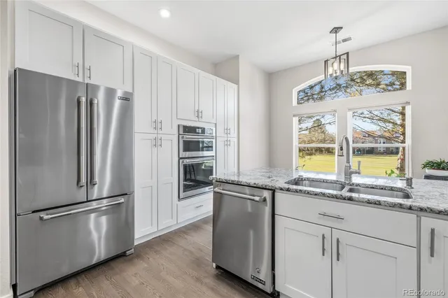 a kitchen with stainless steel appliances granite countertop a refrigerator and a sink