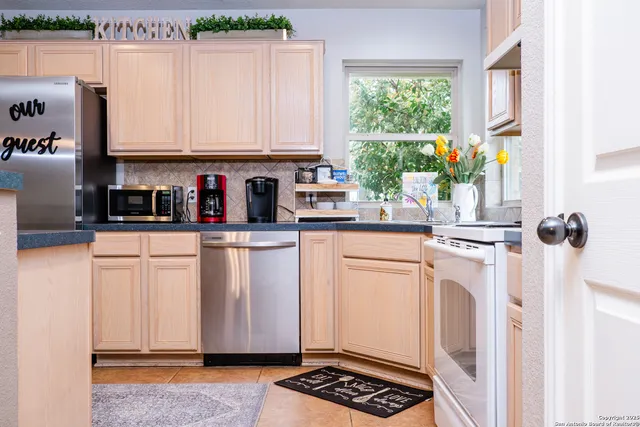 a kitchen with stainless steel appliances granite countertop a refrigerator sink and window