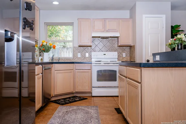a kitchen with stainless steel appliances a white stove top oven and a refrigerator