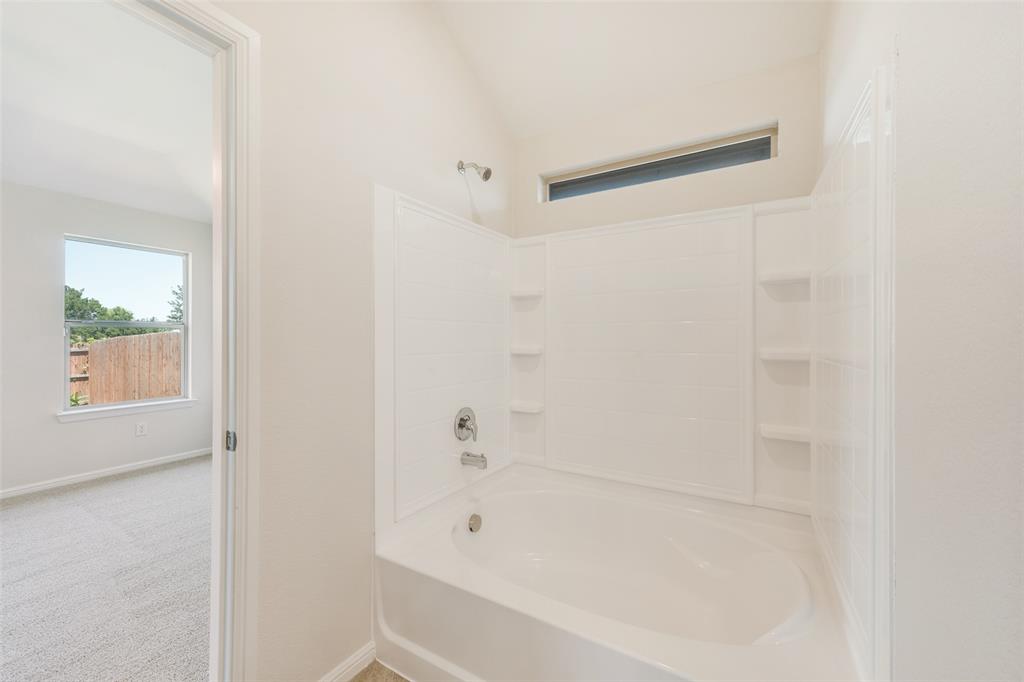 857 Watson Way Crowley, TX 76036 - Photo 20 of 25 Bathtub with integrated shower, chrome fixtures, and built-in shelving