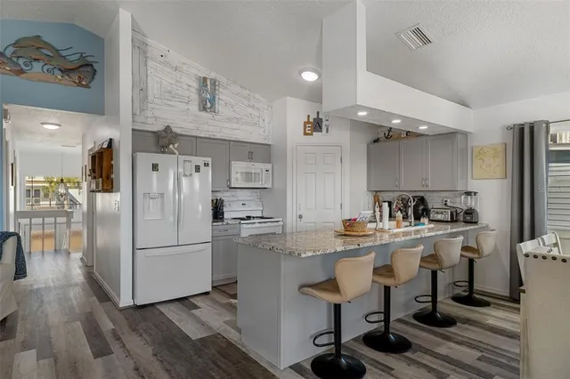a kitchen with refrigerator cabinets and wooden floor
