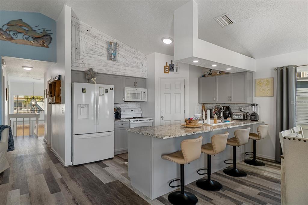 4046 Casa Court Hernando Beach, FL 34607 - Photo 12 of 58 a kitchen with refrigerator cabinets and wooden floor