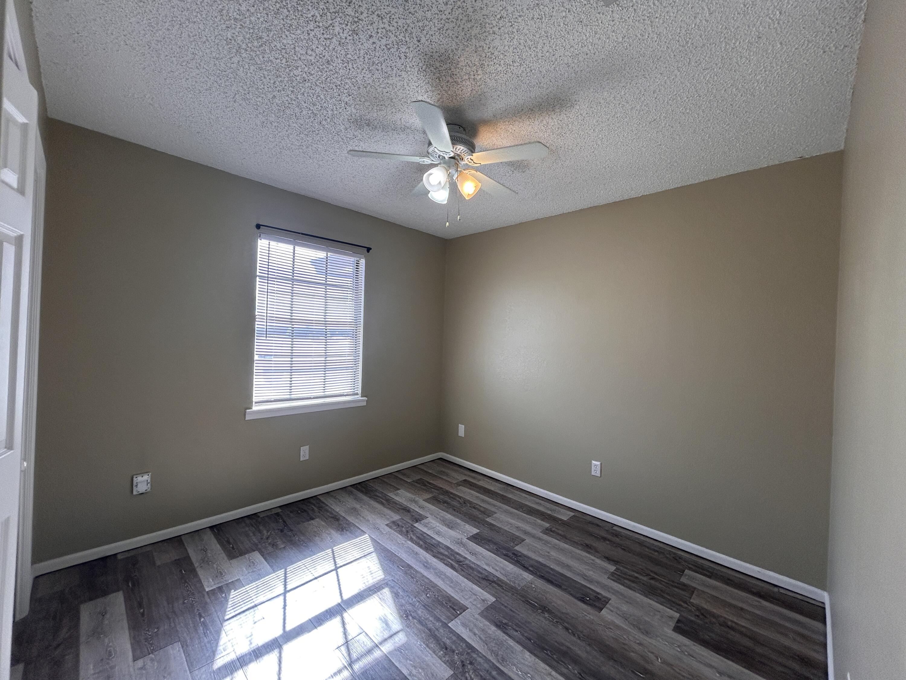 6508 25th Street Lubbock, TX 79407 - Photo 12 of 14 wooden floor in an empty room with a window