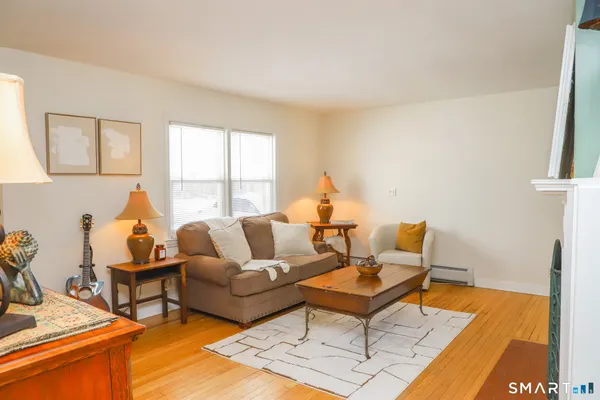 a living room with furniture a rug and a window