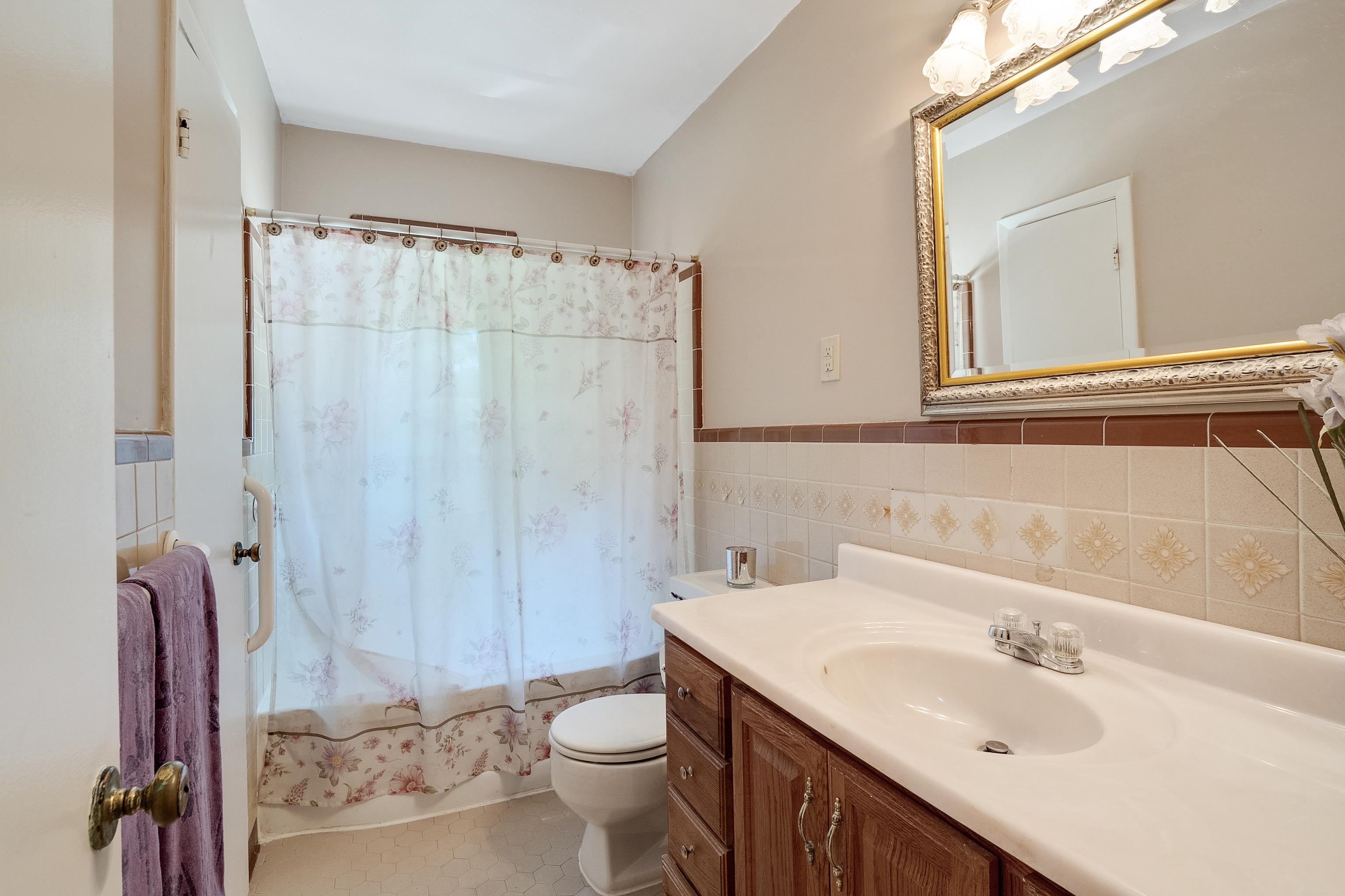 1551 Delmont Road Memphis, TN 38117 - Photo 14 of 25 a bathroom with a sink a toilet and shower curtain