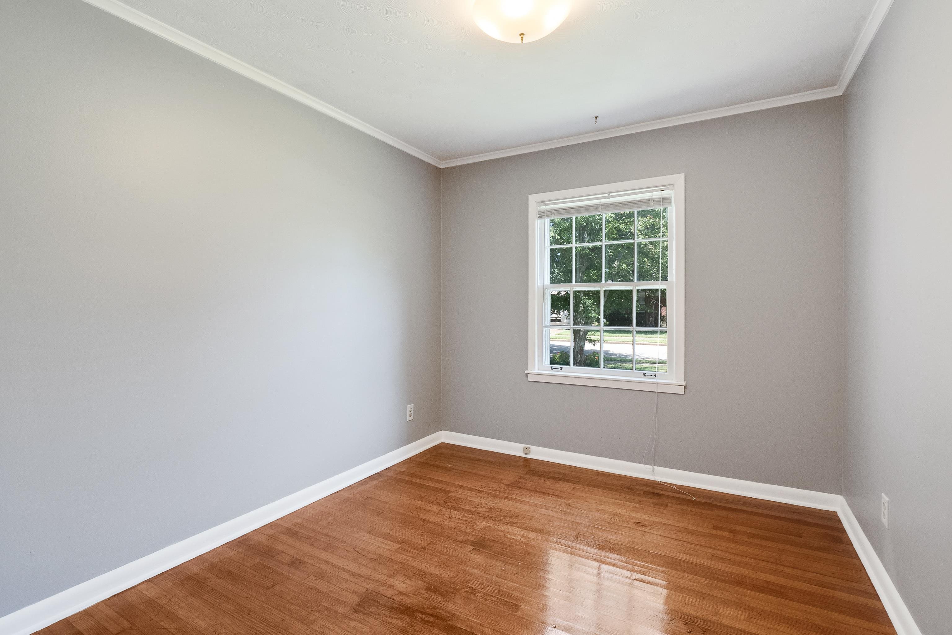1551 Delmont Road Memphis, TN 38117 - Photo 15 of 25 a view of an empty room with wooden floor and a window