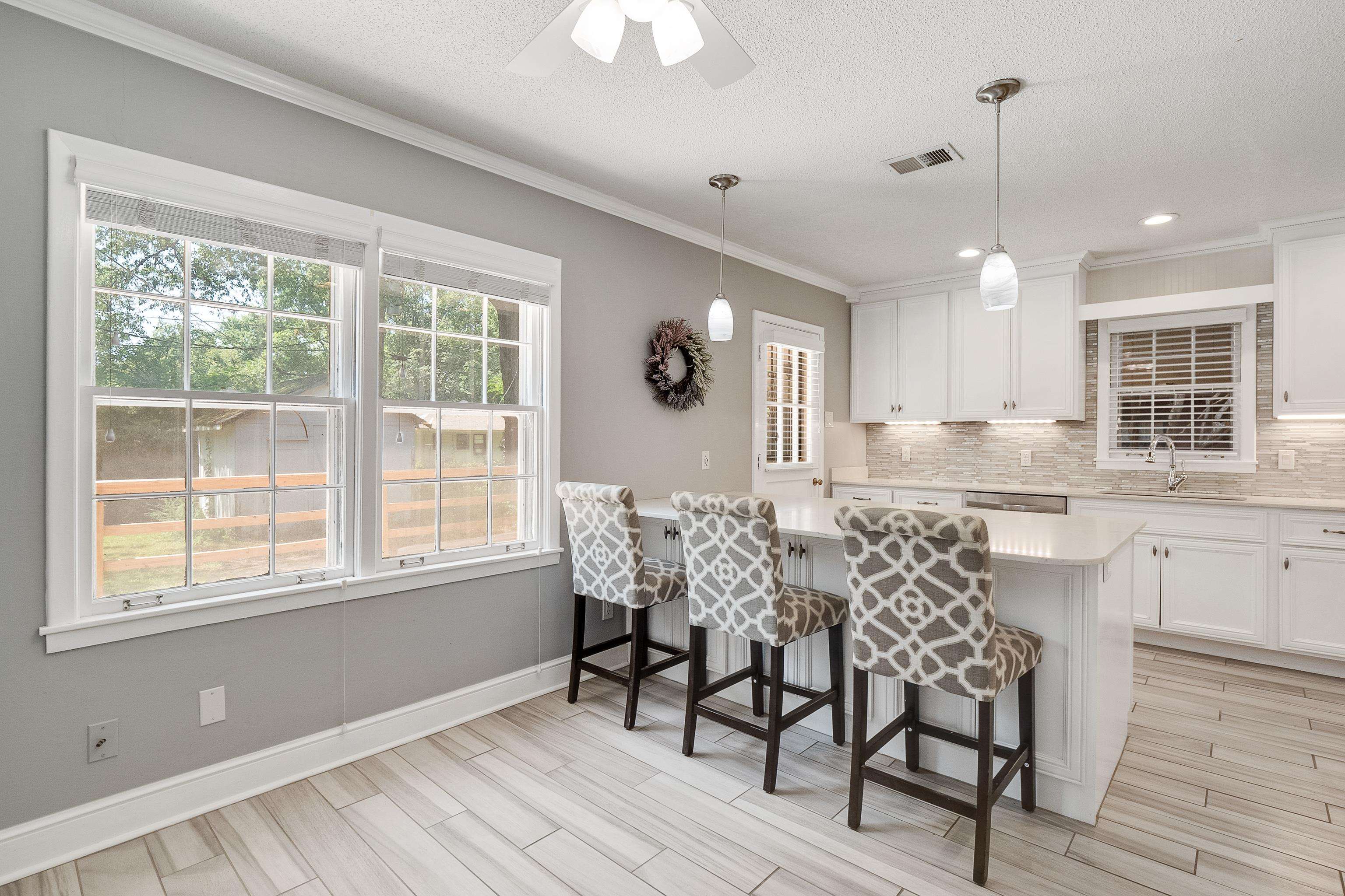 1551 Delmont Road Memphis, TN 38117 - Photo 7 of 25 a kitchen with granite countertop white cabinets and wooden floor