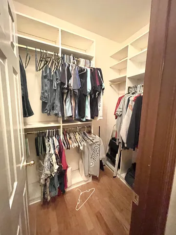 a view of walk in closet with clothes