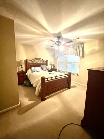 a bedroom with a bed and a dresser next to a window